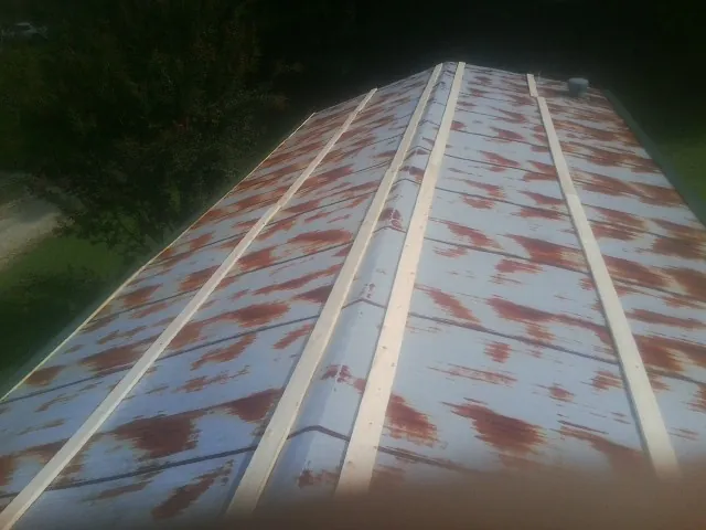 Rusted metal roof panels with new wood purlins before replacement — Storm Damage Roof Repair in Paragonah by Roofing Brothers