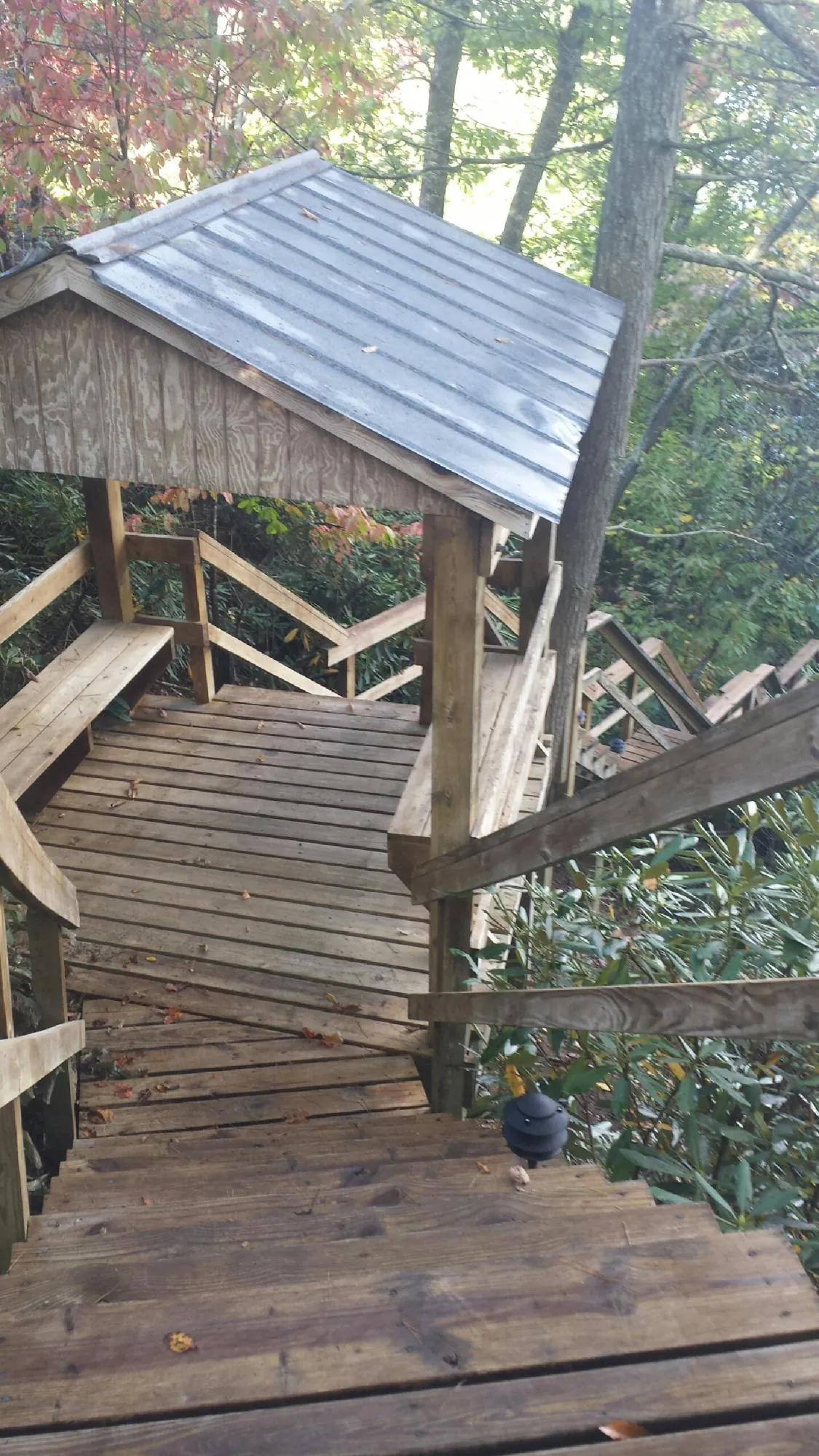 Metal roofed shelter over wooden steps on a wooded walkway — Skylight Repair & Installation work by our crew in Paragonah
