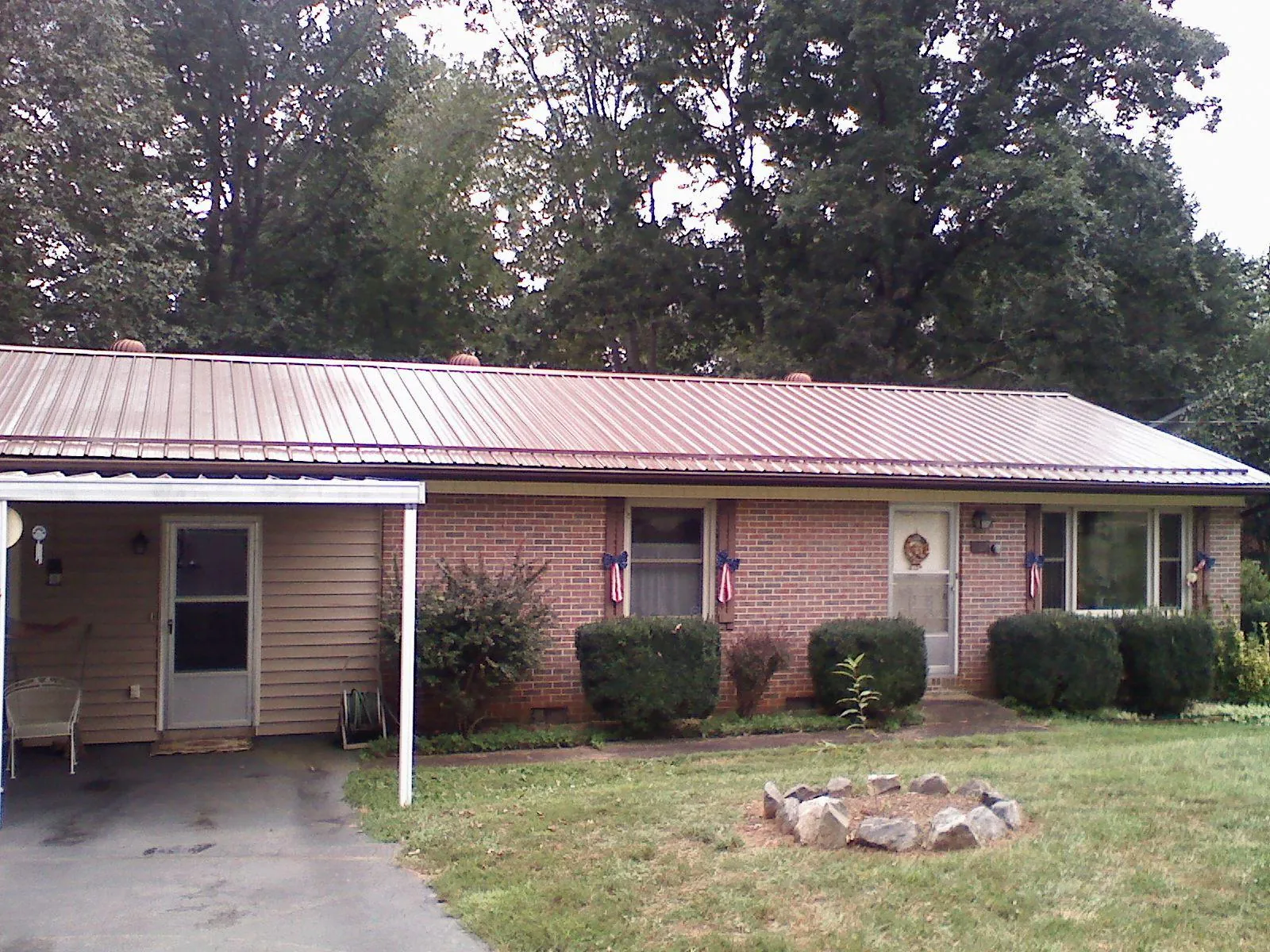 Bronze metal roof and carport on a brick ranch home — Roof Repair work by our crew in Paragonah